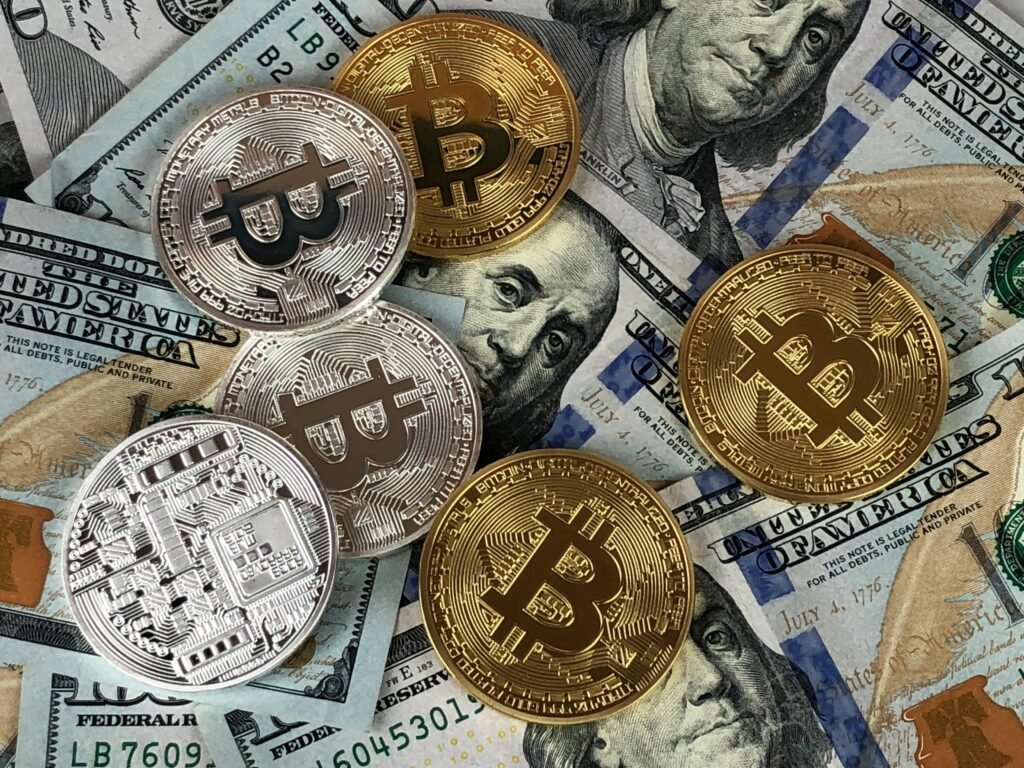 pexels-photo-730564-730564 Close-up of bitcoins and US dollar bills symbolizing modern finance and cryptocurrency.