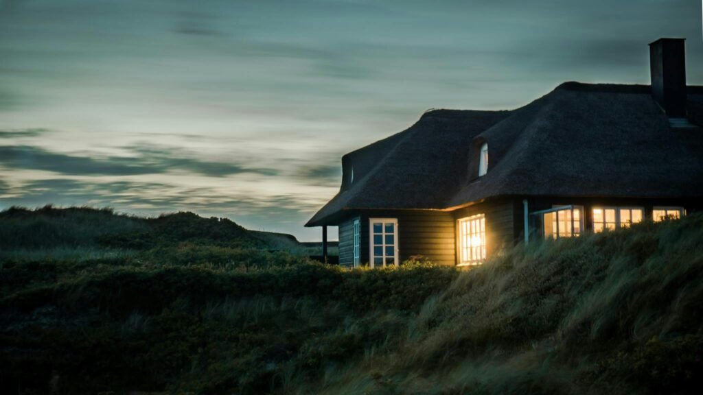 pexels-photo-731082-731082 A scenic view of a cozy bungalow illuminated at dusk, nestled in lush greenery.
