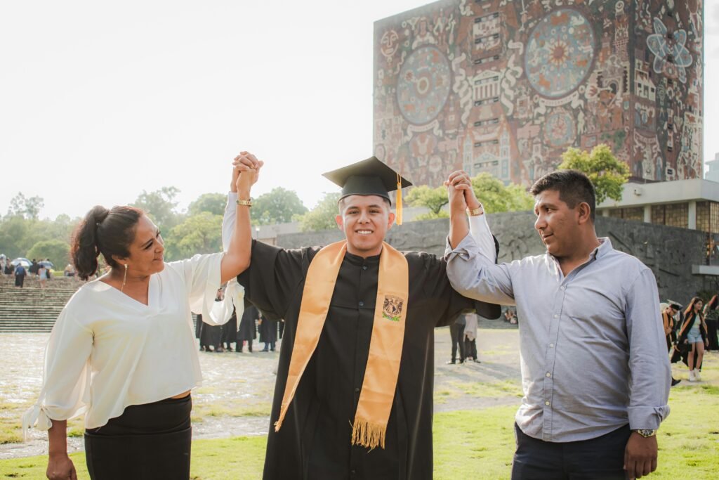Happy graduate celebrating with parents at UNAM library in Mexico City.