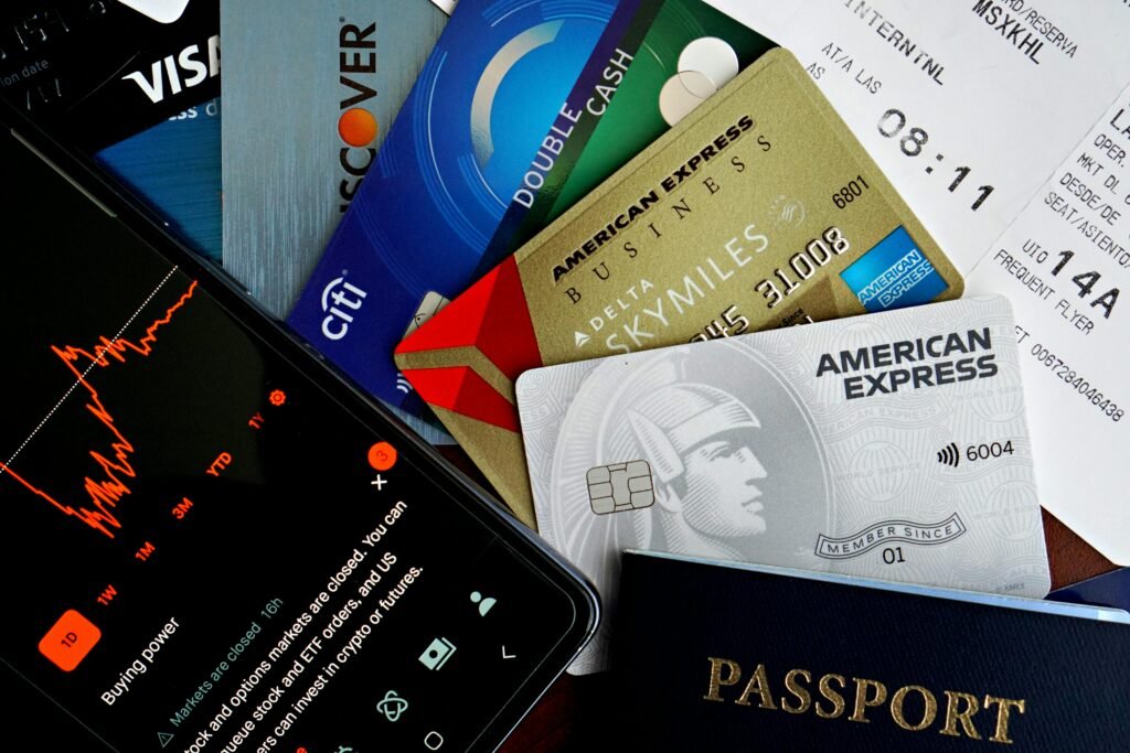 pexels-photo-32642488-32642488 Flat lay of credit cards, passport, and a phone showing stock data, depicting finance and travel.