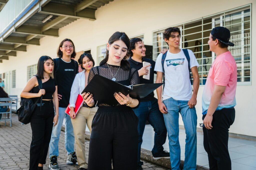A diverse group of university students gathered outdoors in Culiacan, Sinaloa, Mexico, engaging in conversation.